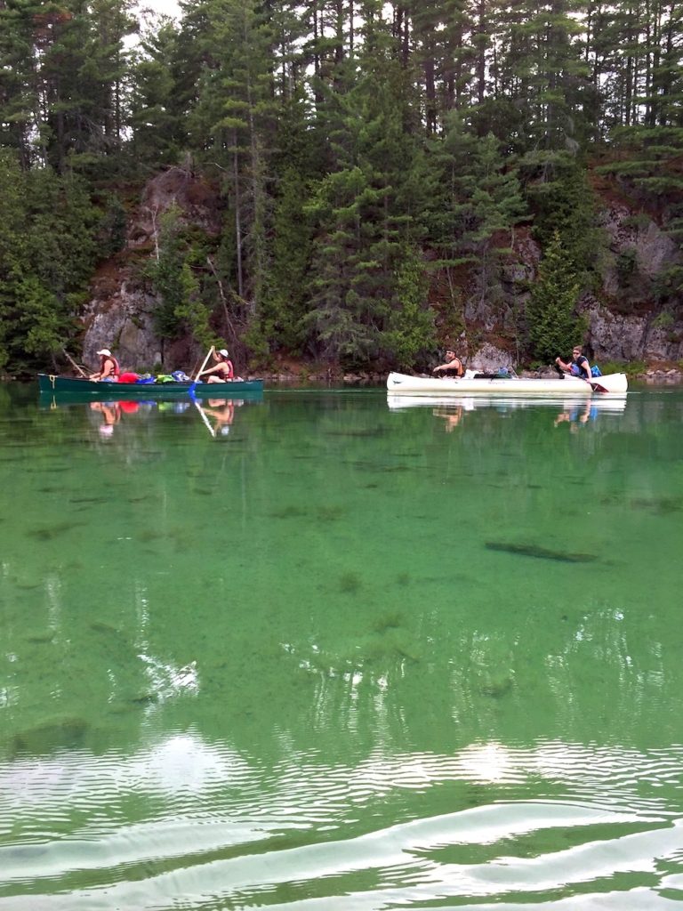 Personnes en canot sur lac turquoise