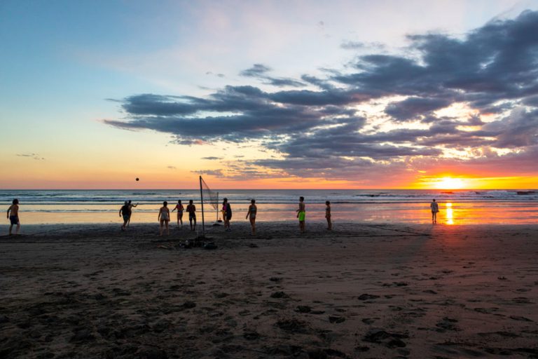 Partie de volleyball de plage au coucher de soleil