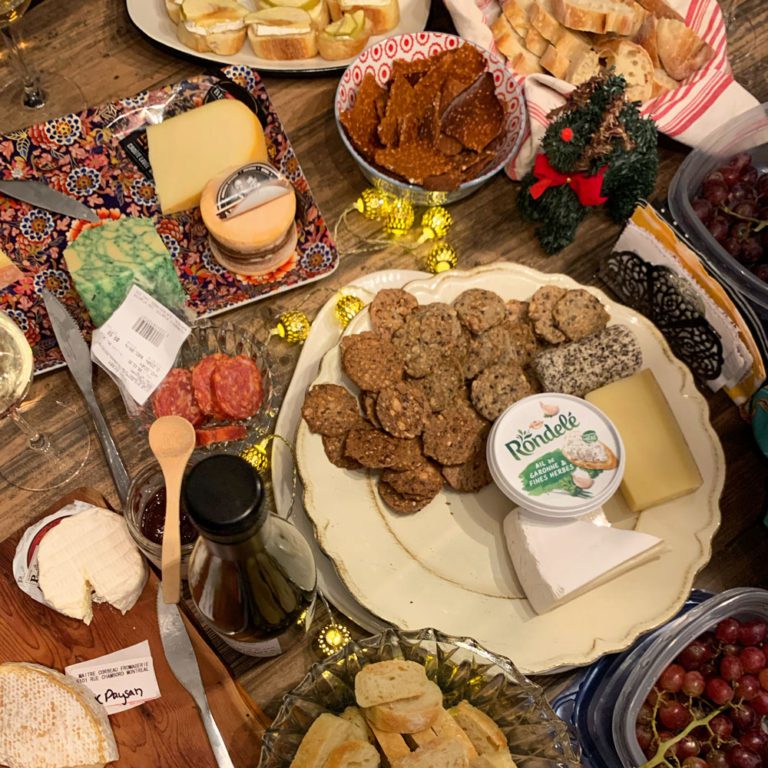Table remplie de fromages, craquelins et vins
