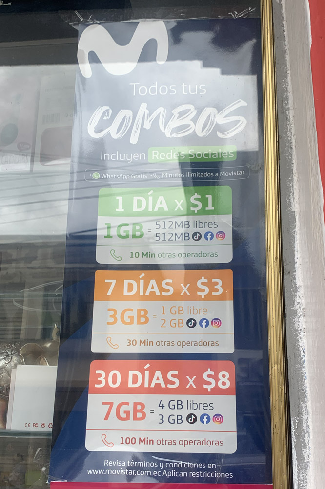 Prix de forfaits cellulaires en Équateur affichés dans la vitrine d'un commerce